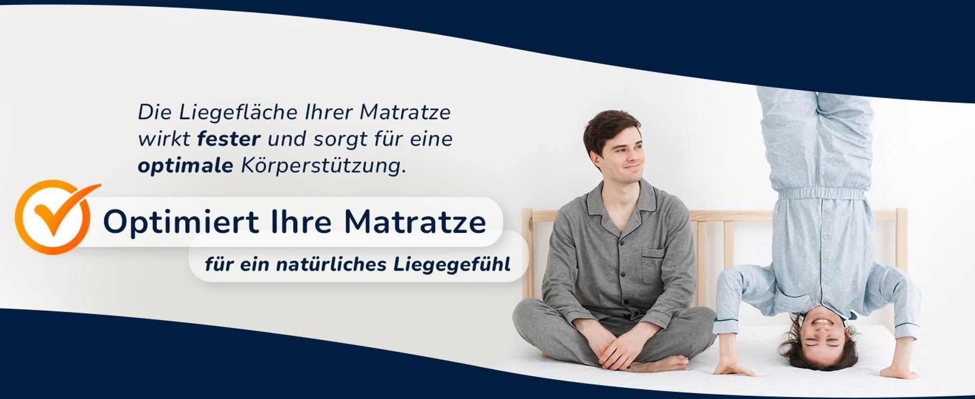 Zwei Personen auf einem Bett, eine sitzt, die andere macht einen Kopfstand