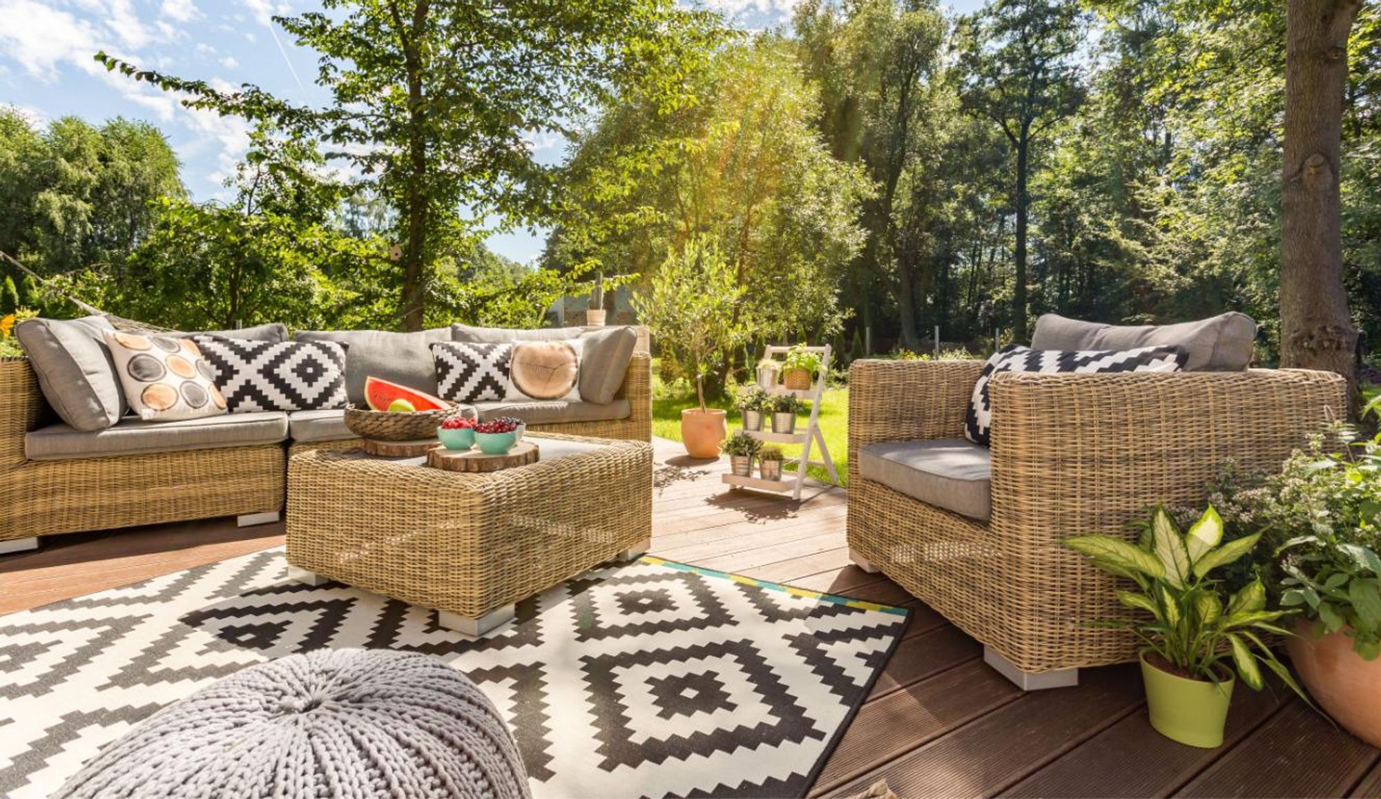Terrasse mit Sitzlounge und Garten im Hintergrund