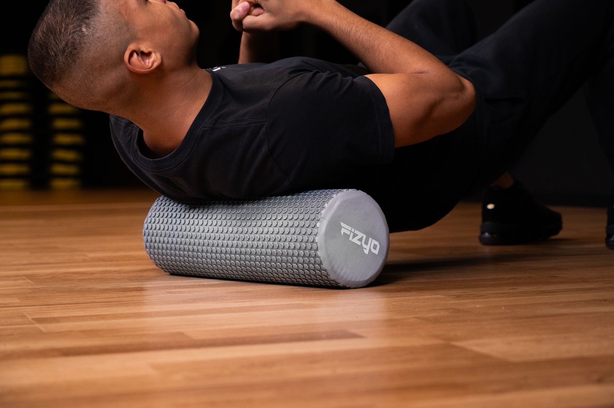 Trénink Fitness s masážním válcem s výstupky 45x15 cm FIZYO — osoba provádí cvičení
