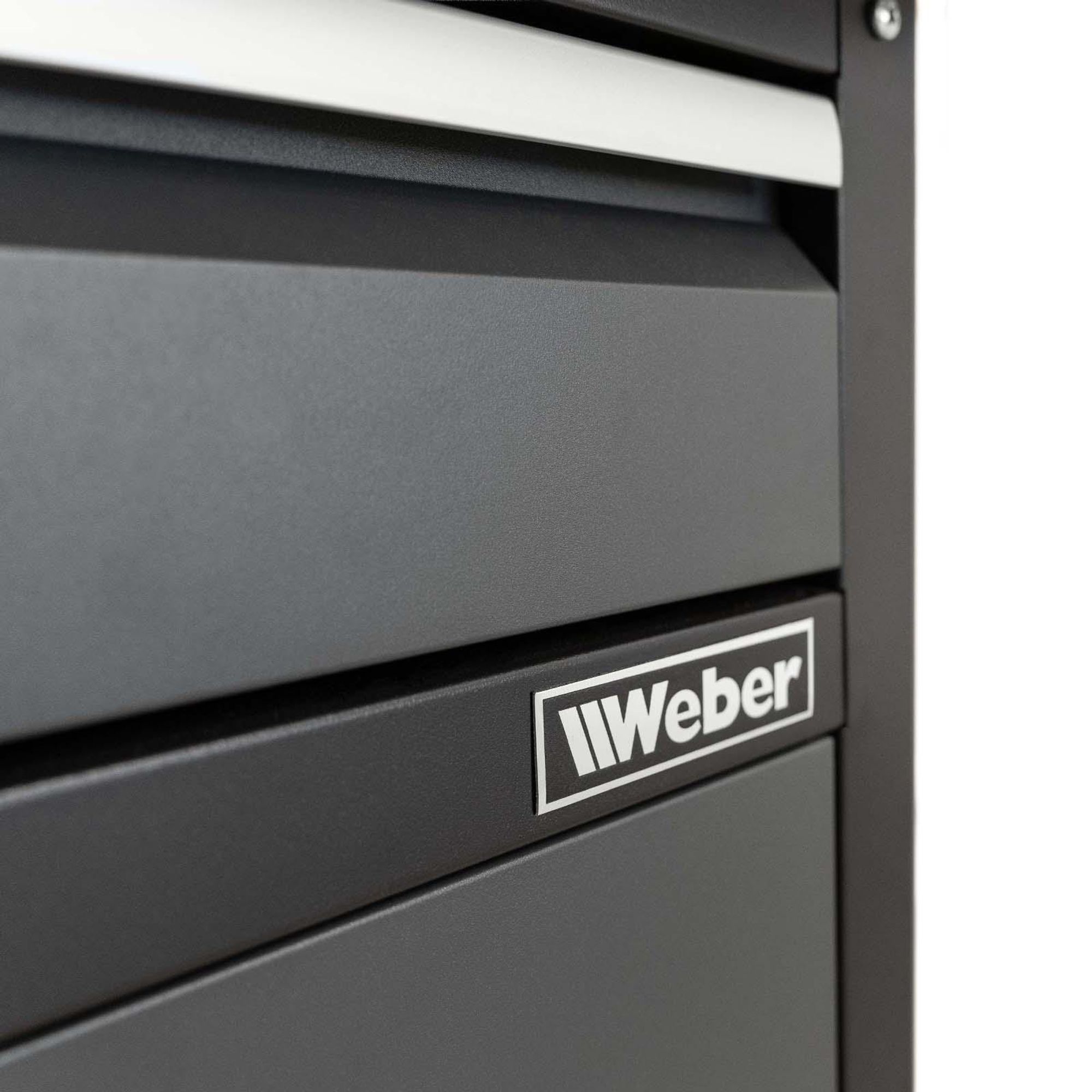 Das Bild zeigt das Weber-Logo auf der Werkbank