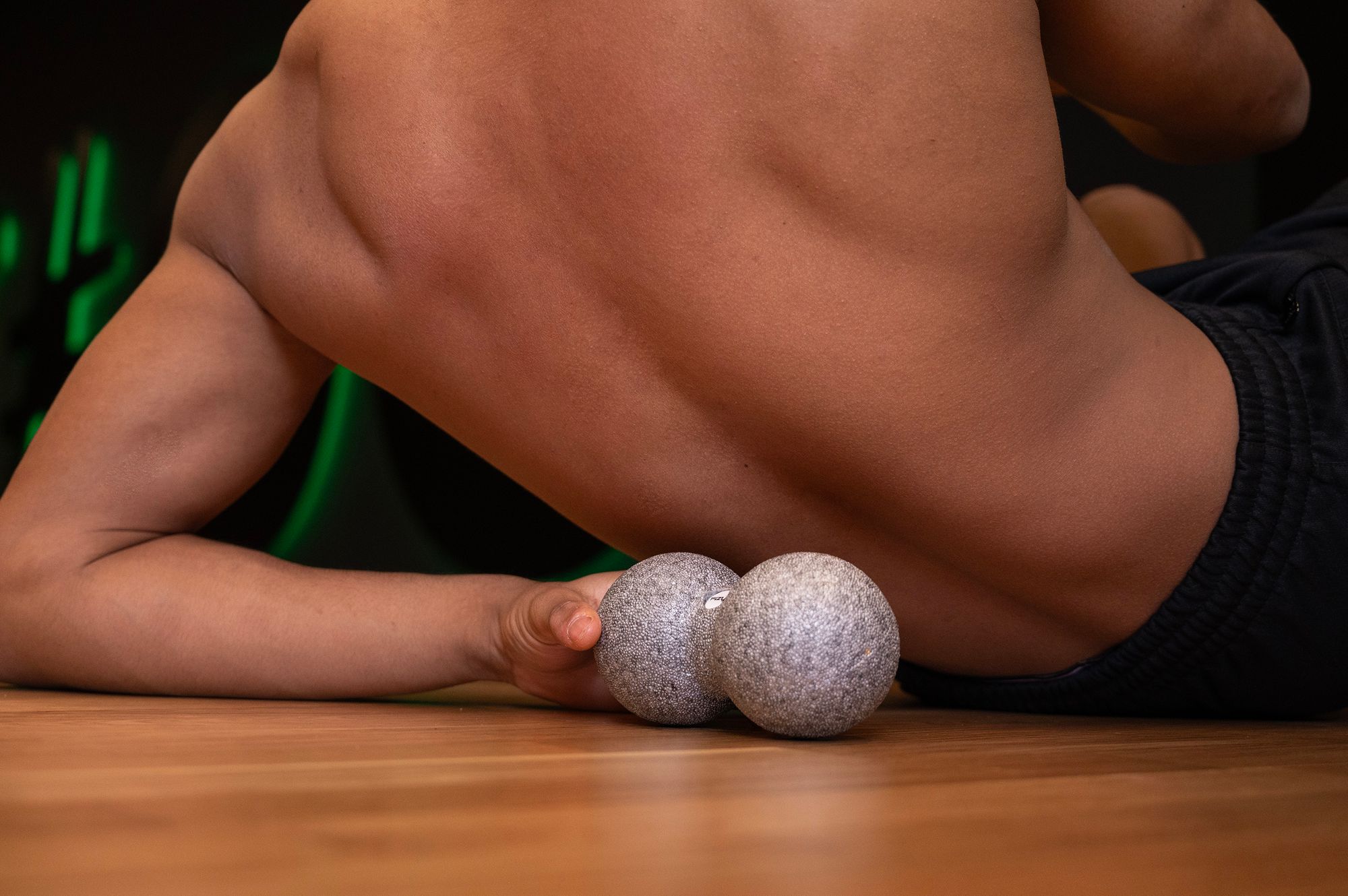 Osoba ćwicząca i wykorzystująca piłkę do masażu duoball FIZYO 16x8 cm