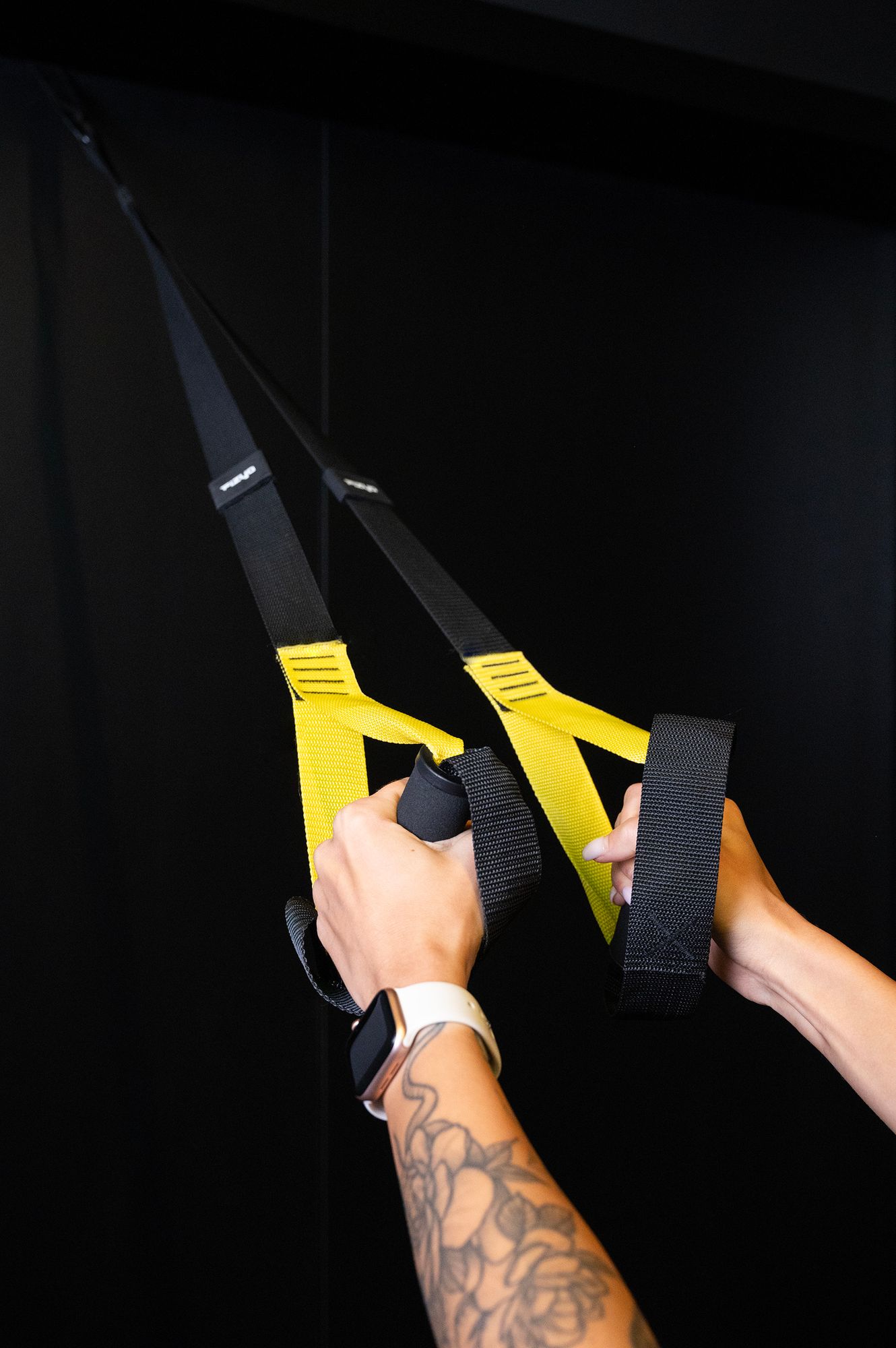 Eine Person trainiert mit TRX-Schlingentrainern.