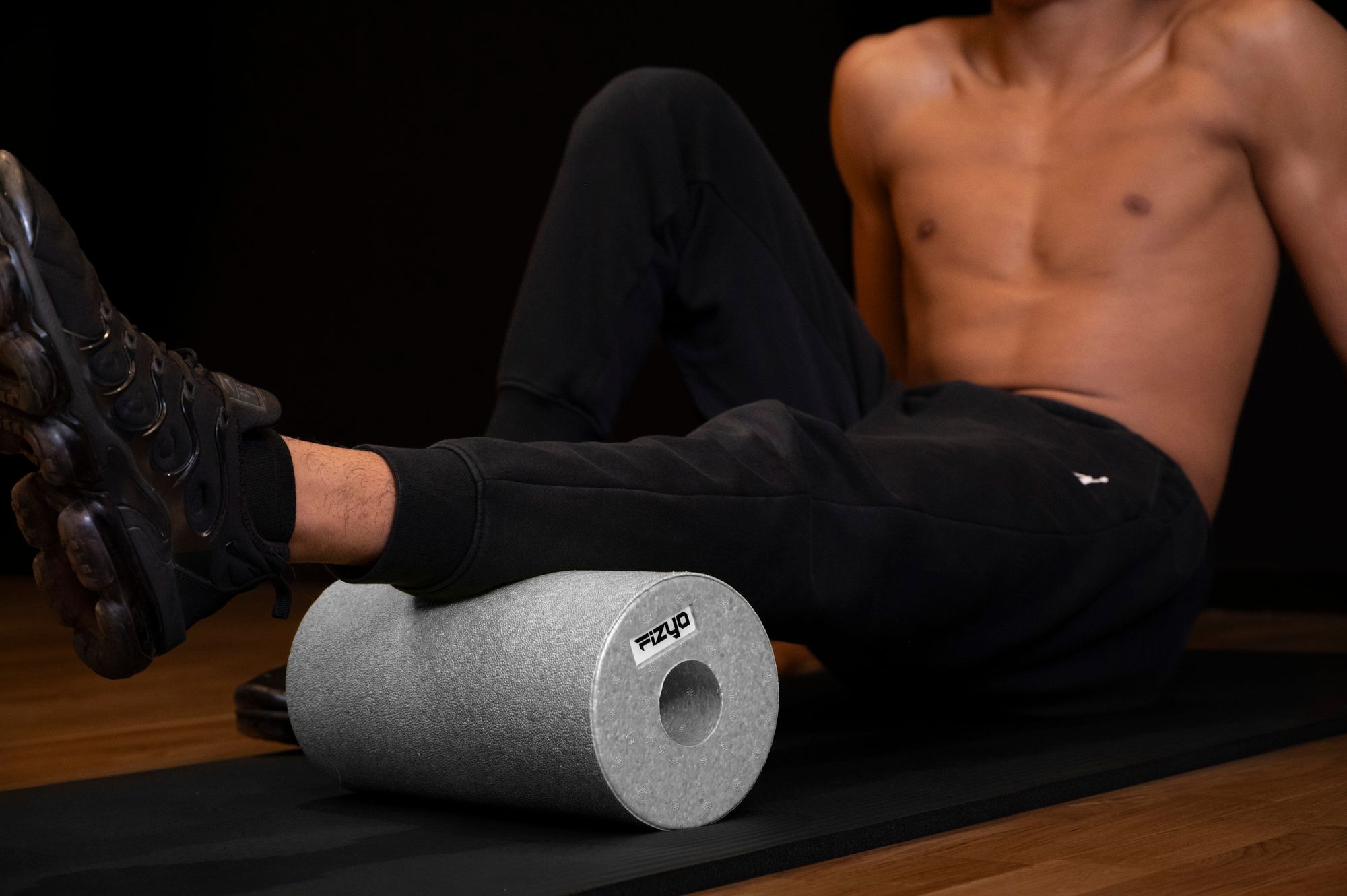 Training mit der FIZYO Massagerolle – Person führt Entspannungs- und Kräftigungsübungen durch.