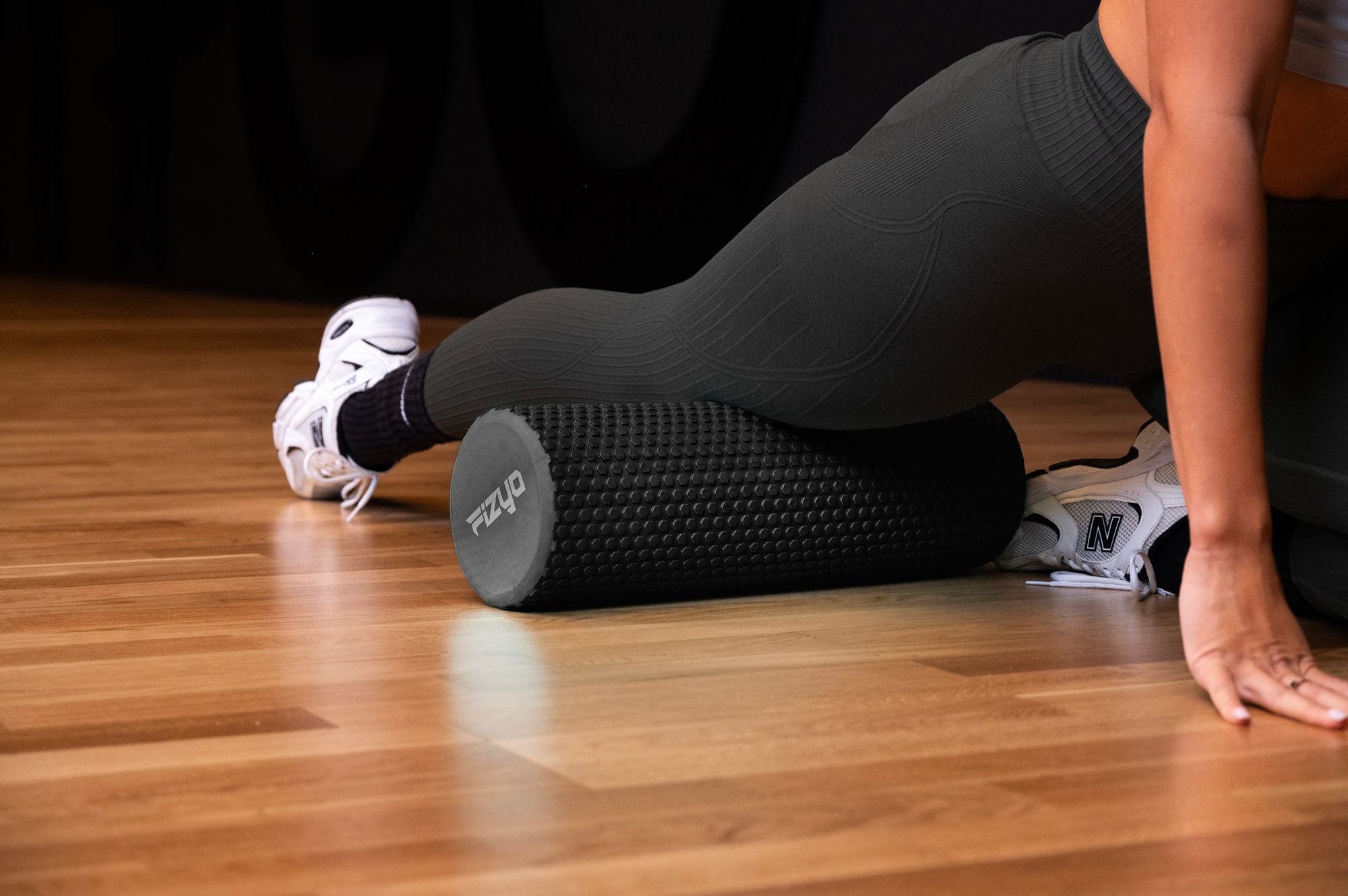 Trening Fitness z wałkiem do masażu z wypustkami 45x15 cm FIZYO — osoba wykonuje ćwiczenia