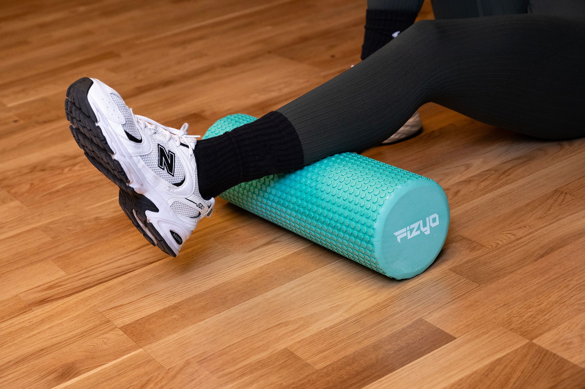 Fitness-Training mit einer Noppen-Massagerolle 45x15 cm FIZYO – eine Person führt Übungen aus