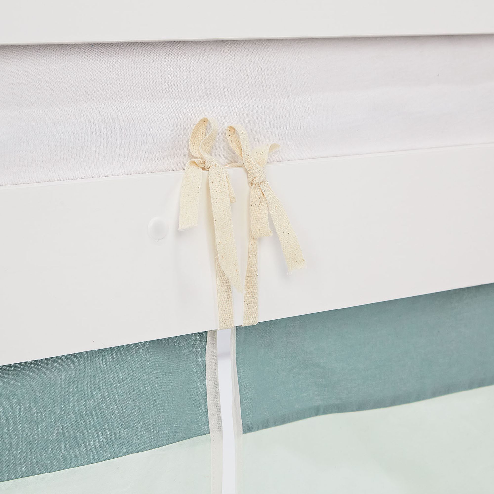 Bettvorhang wird mit Schlaufen ans Bett geknotet