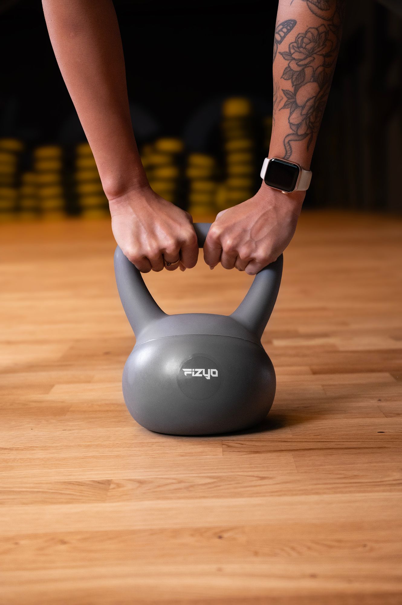 Osoba ćwiczy przy pomocy ciężarka hantla miękki kettlebell FIZYO
