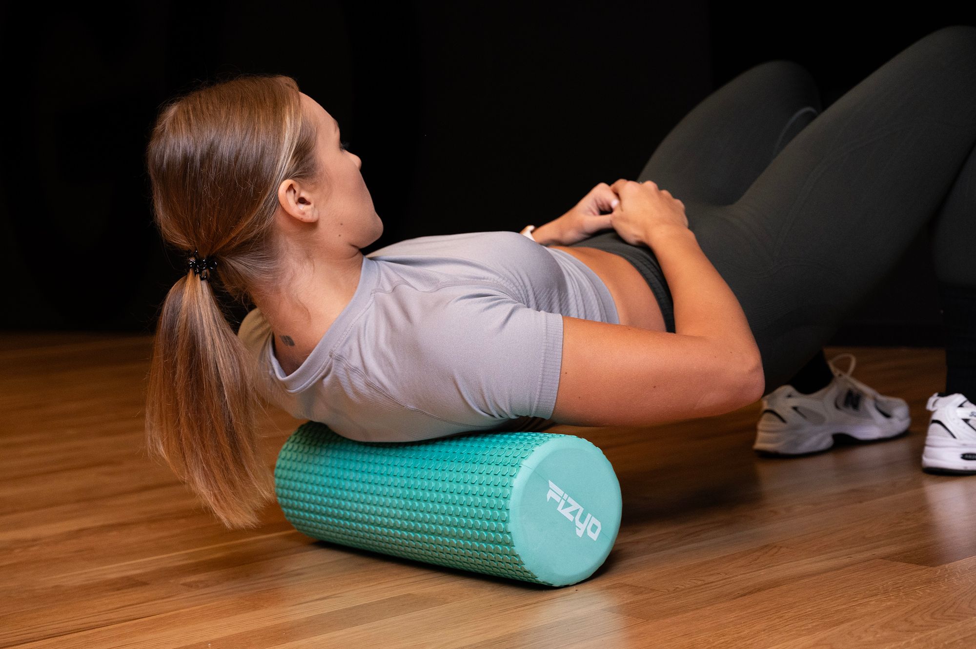 Fitness-Training mit einer Noppen-Massagerolle 45x15 cm FIZYO – eine Person führt Übungen aus