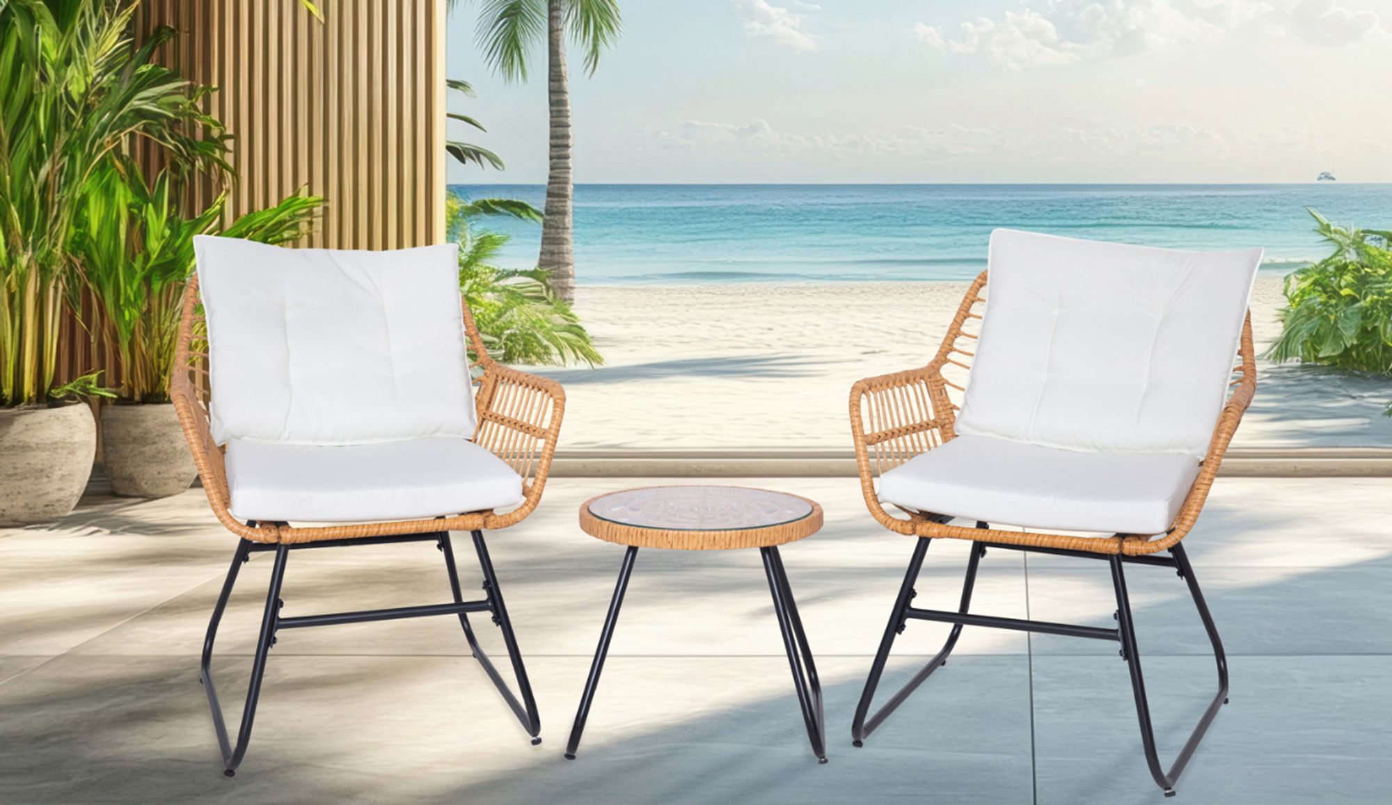 Zwei Rattanstühle mit weißen Polstern und ein Tisch auf Terrasse mit Blick auf Strand und Meer