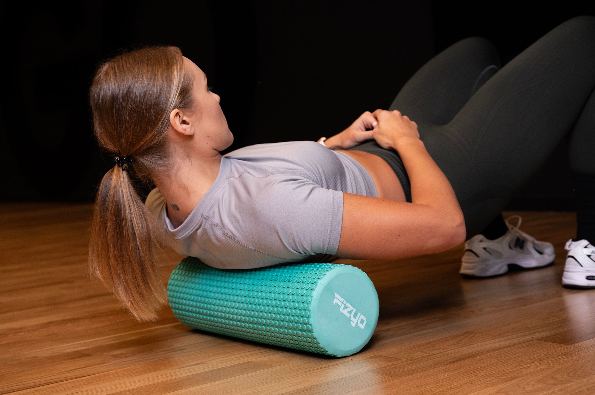 Trening Fitness z wałkiem do masażu z wypustkami 45x15 cm FIZYO — osoba wykonuje ćwiczenia