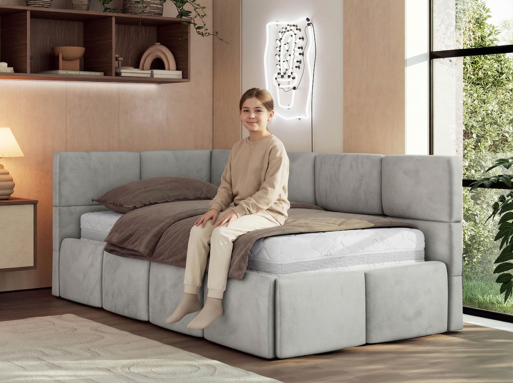 Kind sitzt auf einem hellgrauen Polsterbett im modernen Schlafzimmer.