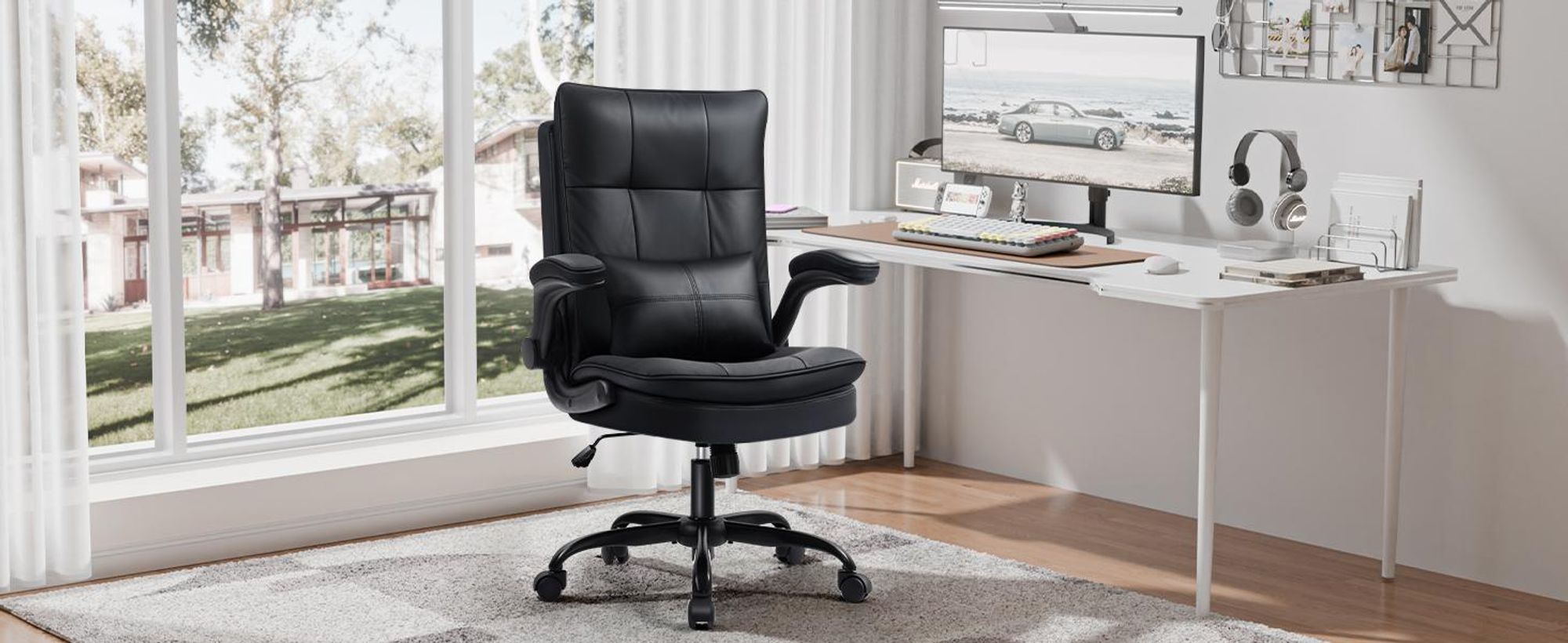 Schwarzer Bürostuhl in Lederoptik im hellen Homeoffice am Schreibtisch, ergonomisch gepolstert