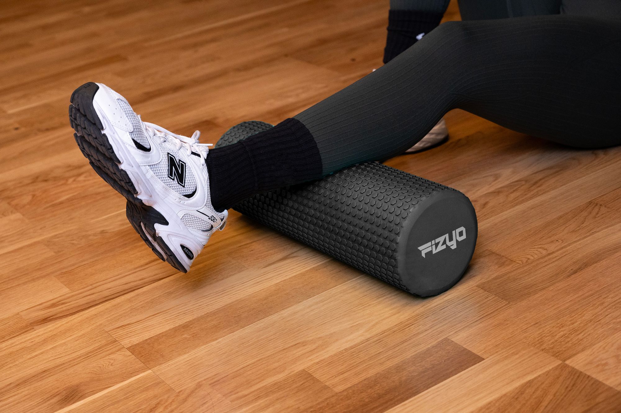 Trening Fitness z wałkiem do masażu z wypustkami 45x15 cm FIZYO — osoba wykonuje ćwiczenia